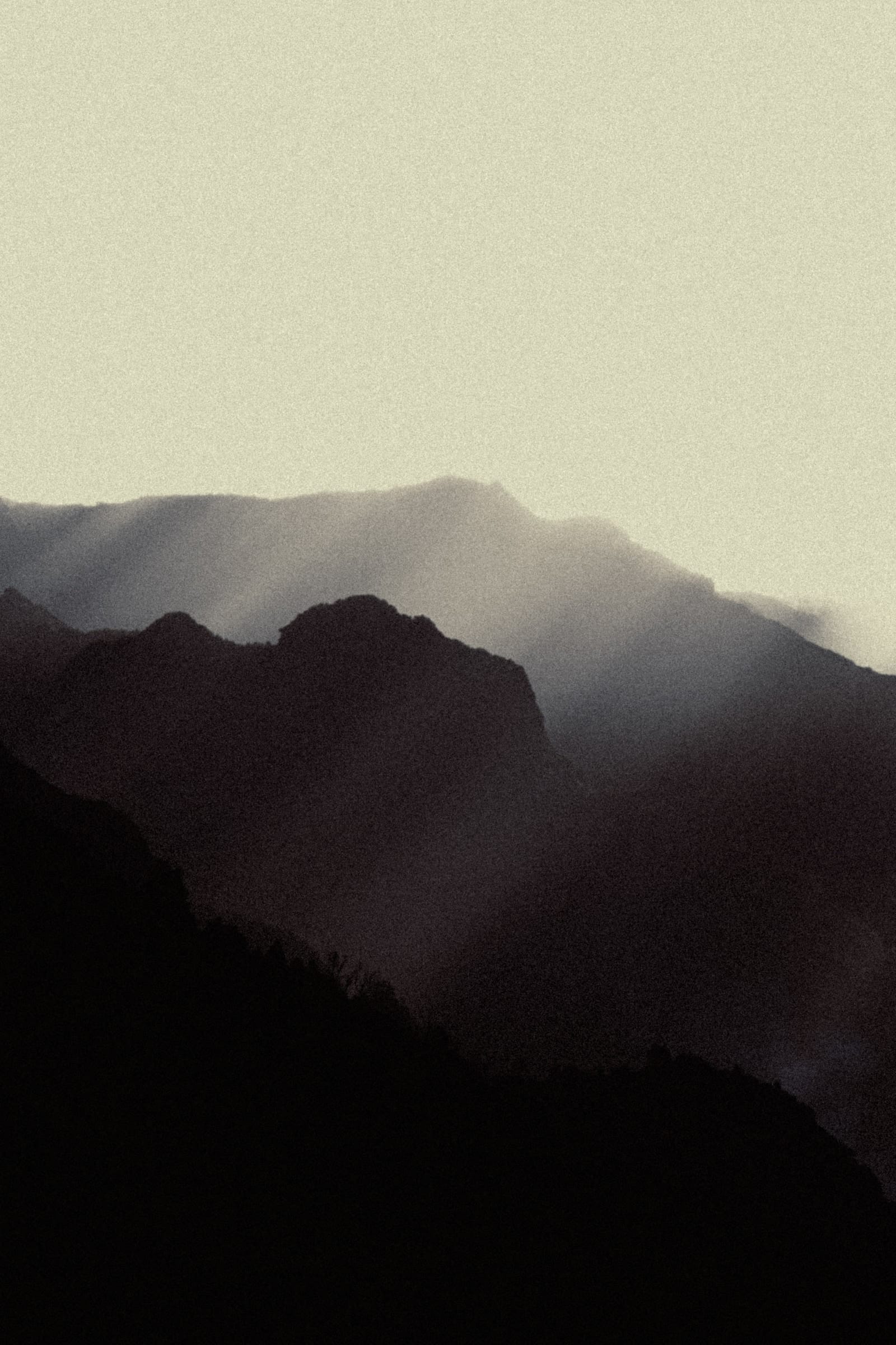 Layered mountain ridges in Madeira receding beneath pale diffused light.
