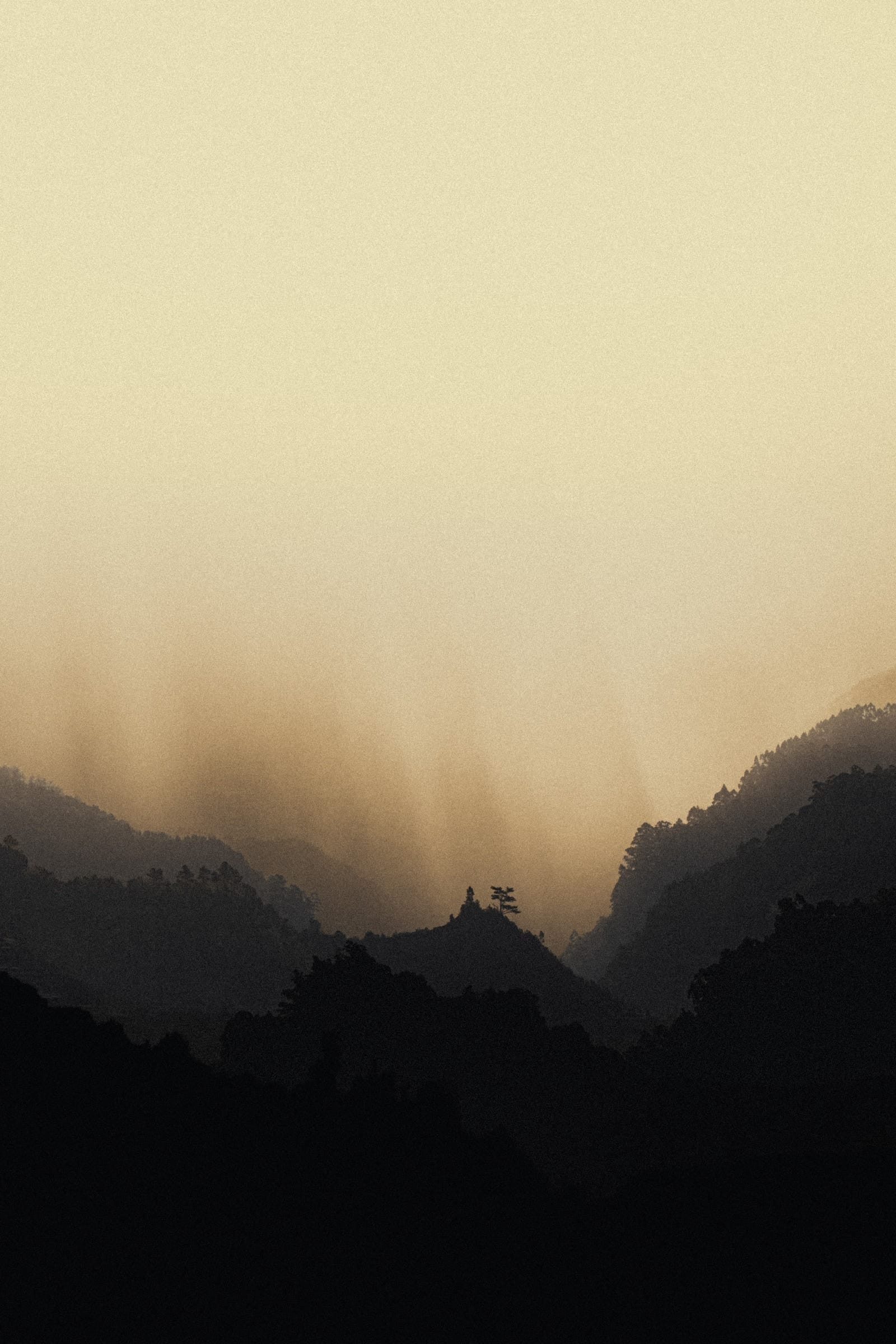 Sunbeams falling through haze into a deep valley between Madeira mountain ridges.