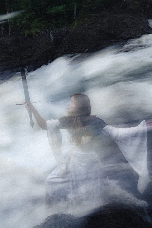 A white-robed sword-bearer blurred into the movement of falling water