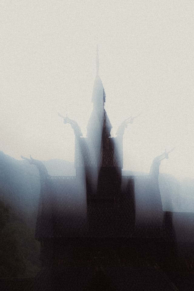 An overexposed stave church silhouette dissolving into white mist